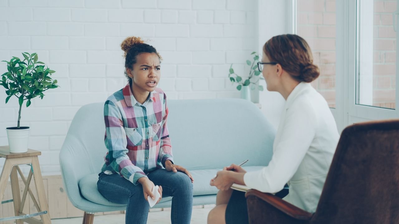 Therapist and patient in conversation during a counseling session indoors.